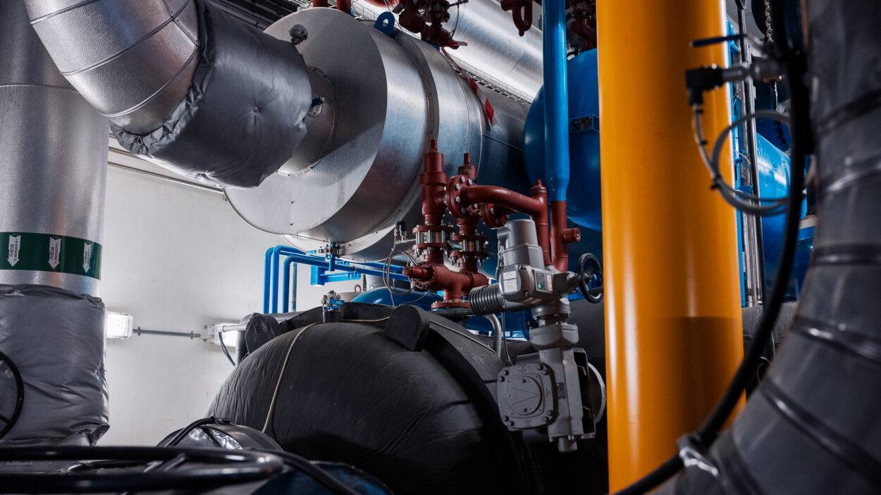 Anlegg for fjernvarme, med rør og maskineri.